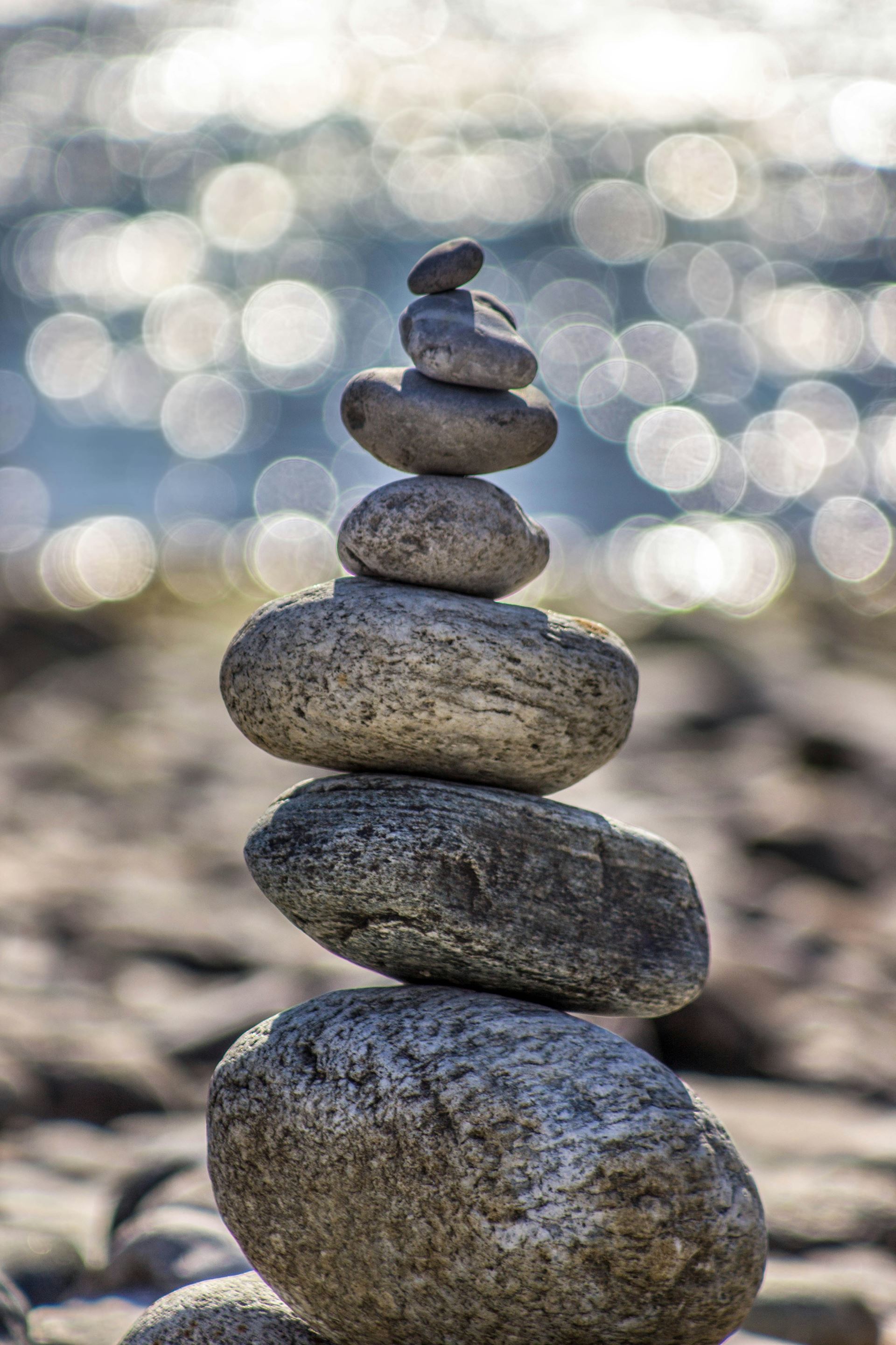 A tower of pebbles balanced on top of each by the waterside.